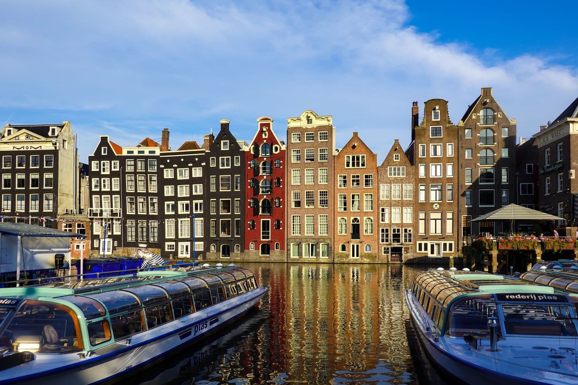 Kleurrijke grachtenpanden met rondvaartboten