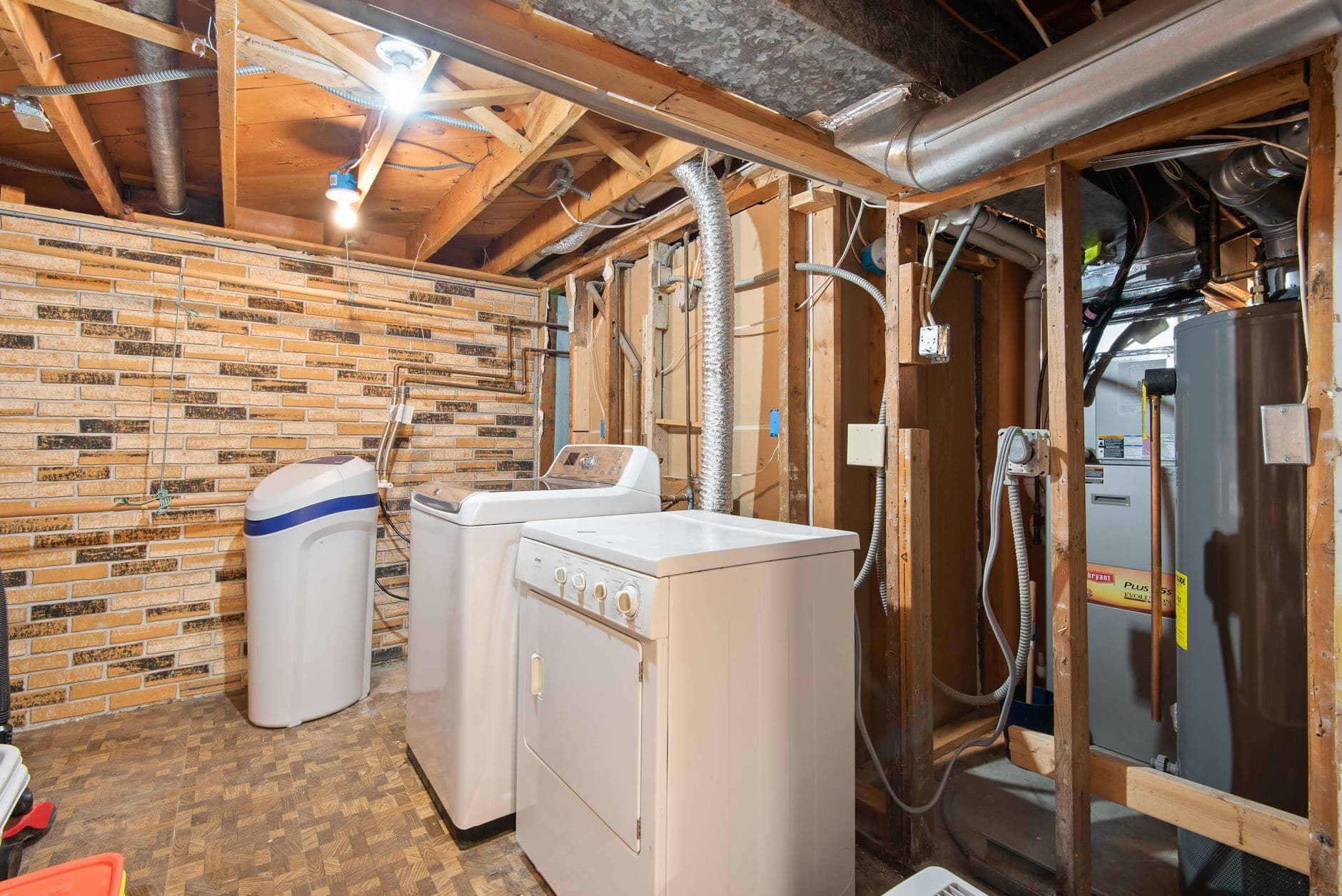 Kelder met wasmachine, droogkast en een open houten wandstructuur