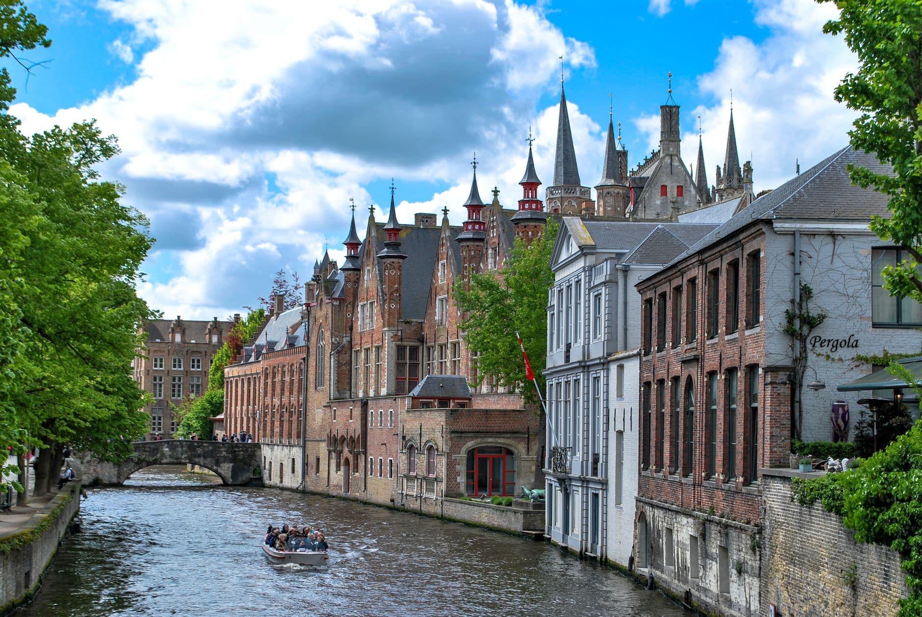 Rondvaartboot op een reitje langs historische gevels in Brugge