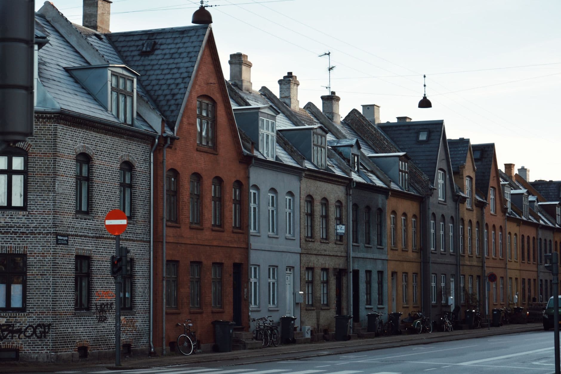 Straat met oude rijhuizen, deels in baksteen, met leien daken