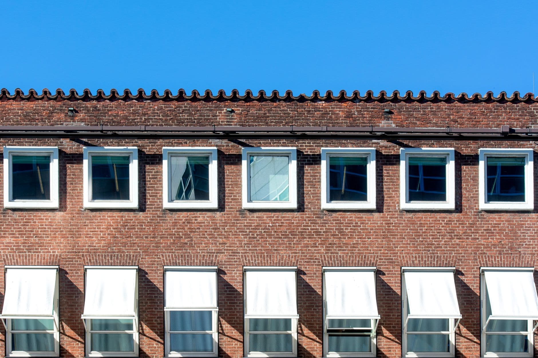 Bovenste verdieping van een bakstenen gebouw met een rij ramen