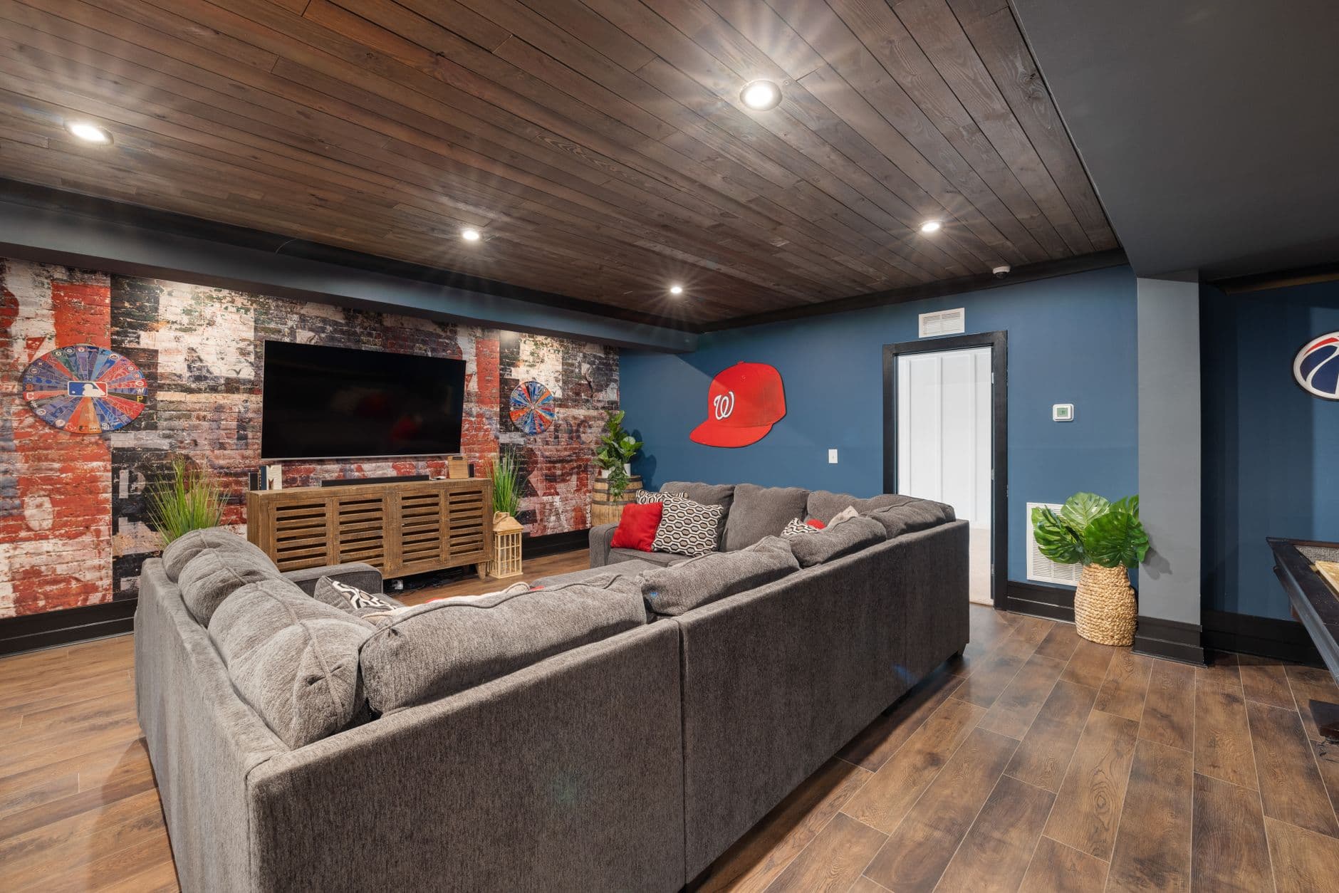 Kelder ingericht als woonkamer met een zetel en een televisie