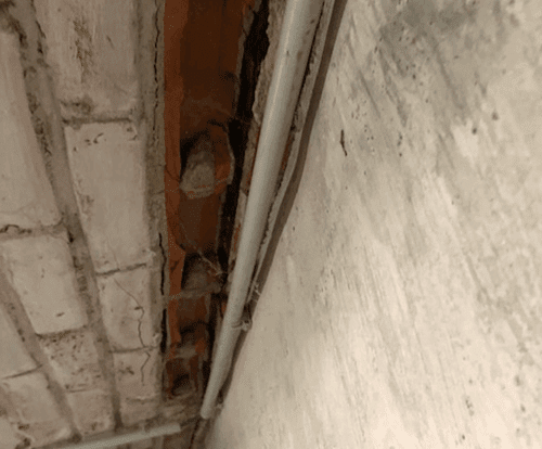Vochtige keldermuur met afbrokkelend voegwerk